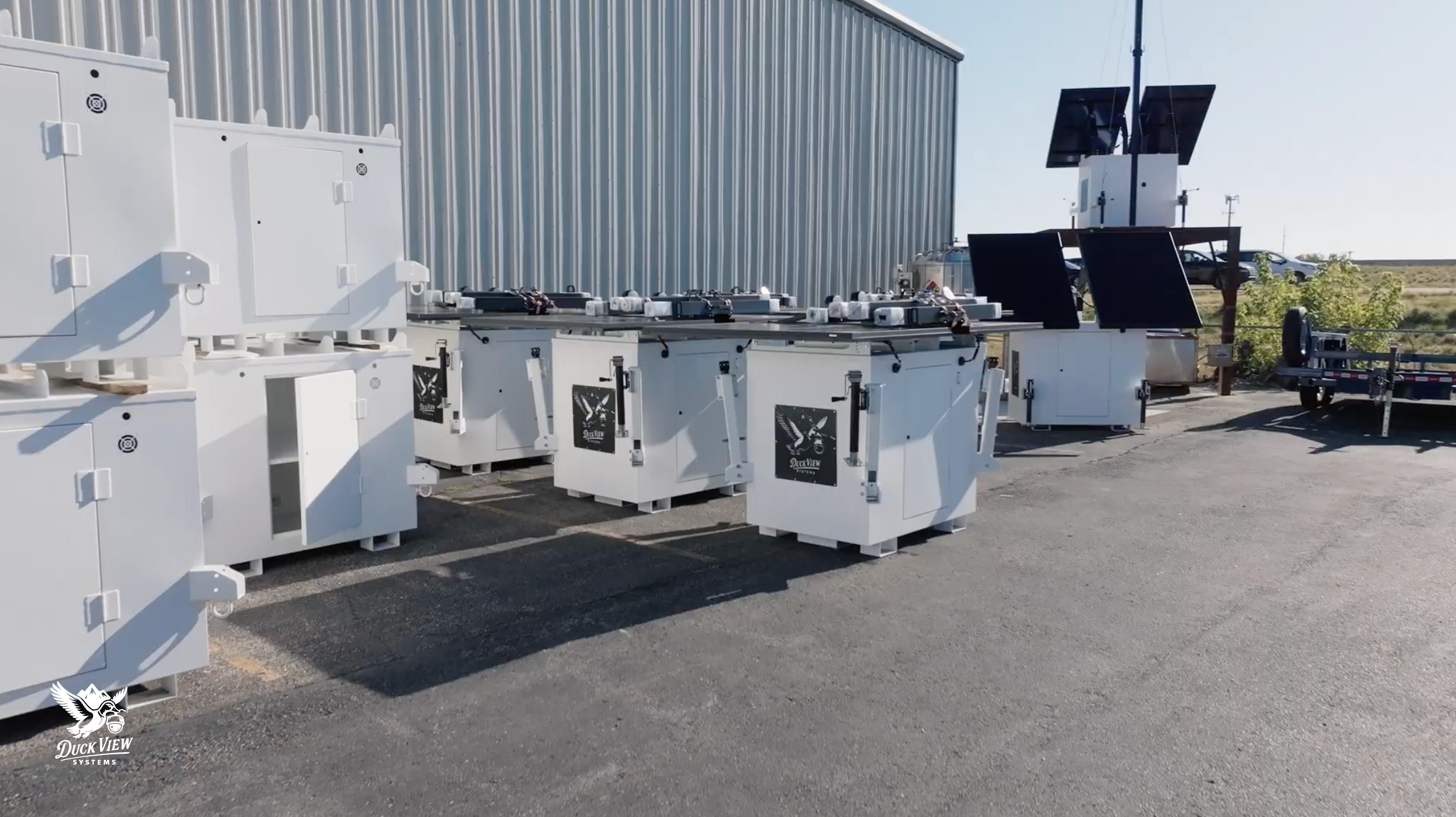 Mobile Security Camera Trailer Units in Production Multiple mobile security camera trailer units and solar-powered housings staged outdoors, showing equipment assembly and readiness for deployment.