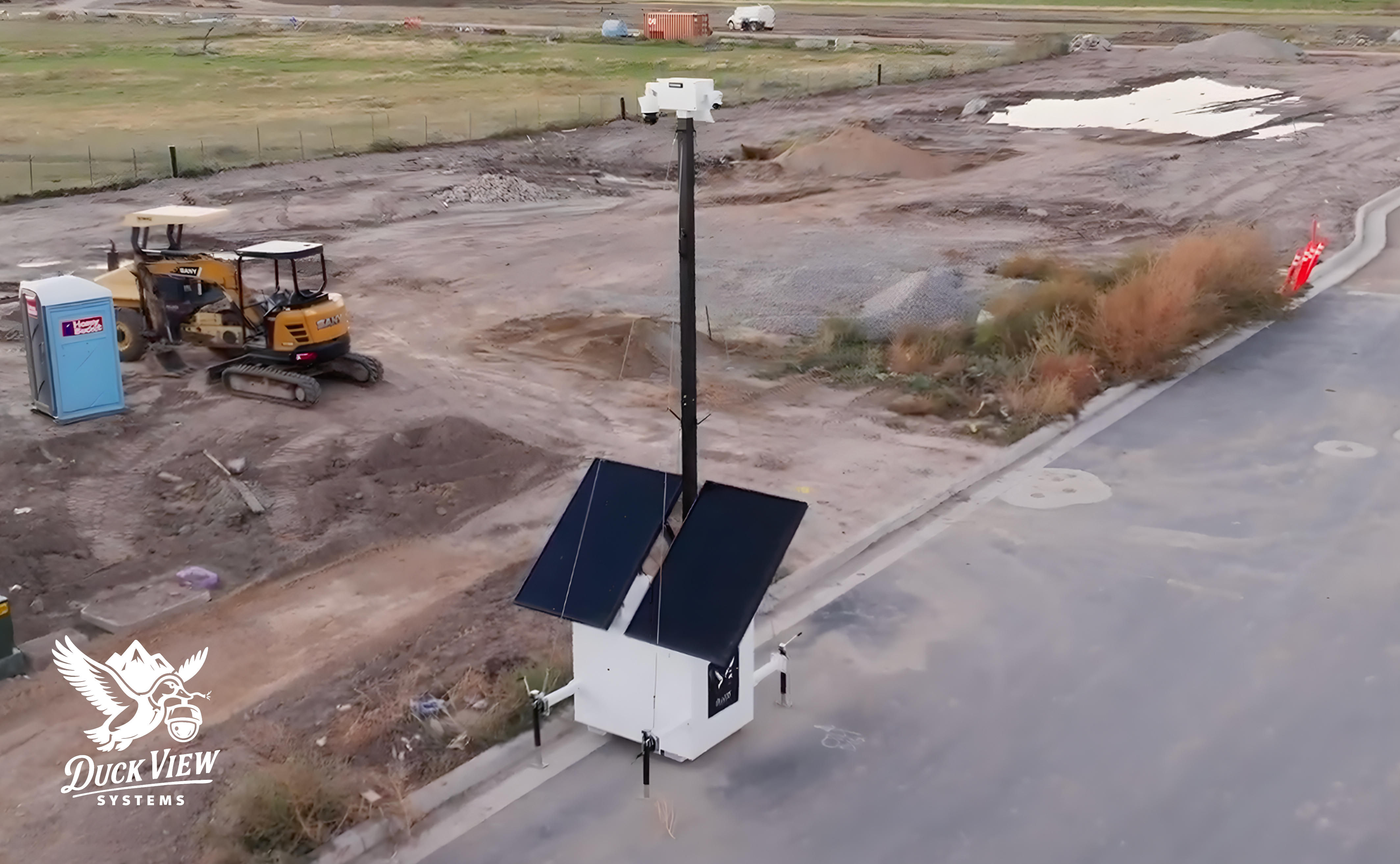 Remote Asset Monitoring for Active Construction Sites Remote asset monitoring tower with solar panels and elevated cameras overseeing an active construction site to deter theft and provide real-time visibility